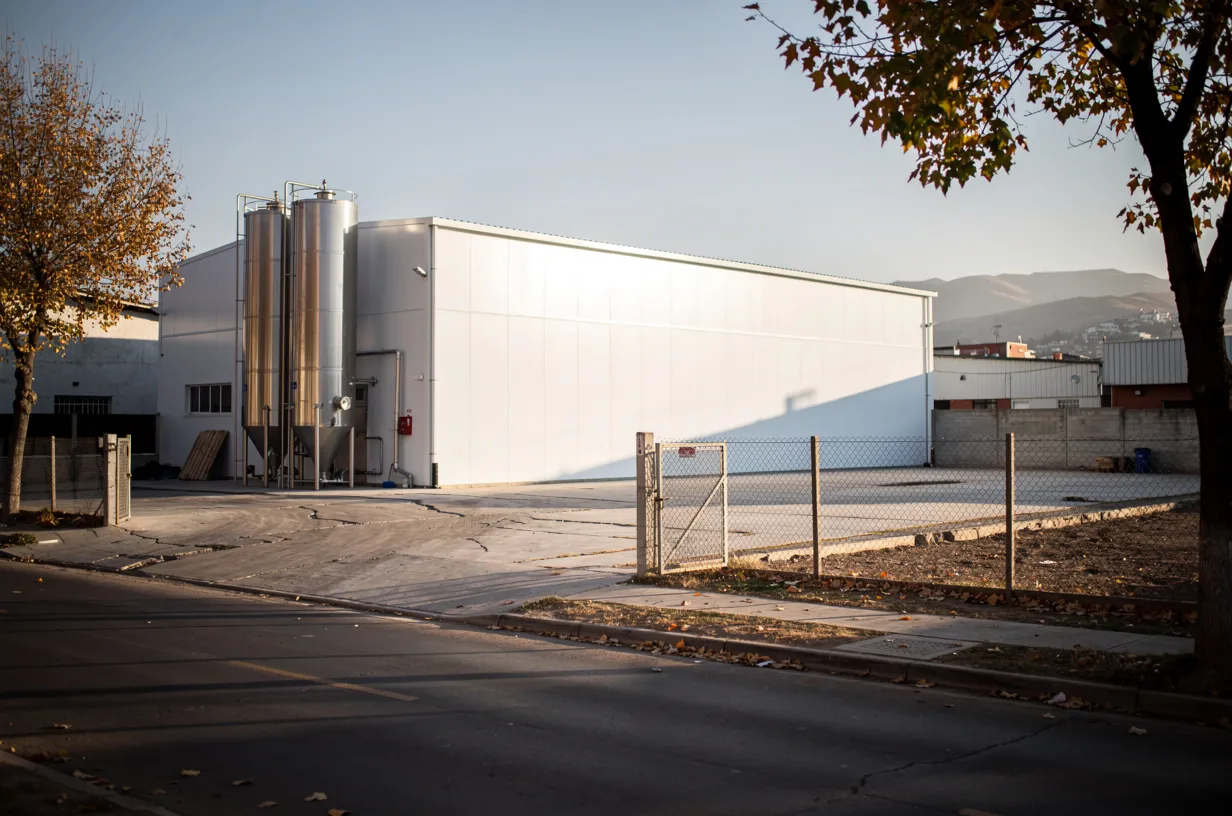 Planta industrial pequeña en una zona de bodegas, con espacio libre para una ampliación