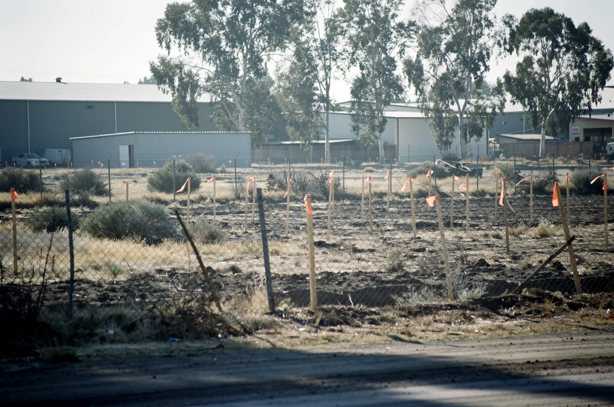 Terreno en la periferia de una ciudad donde se evaluará un proyecto, con estacas de topografía
