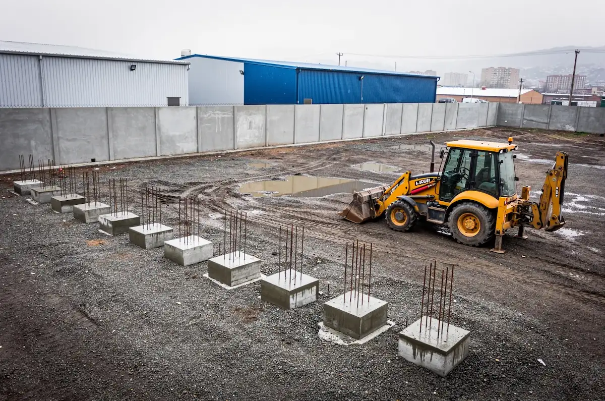 Obra inicial de una planta industrial liviana con fundaciones de hormigón recién hechas